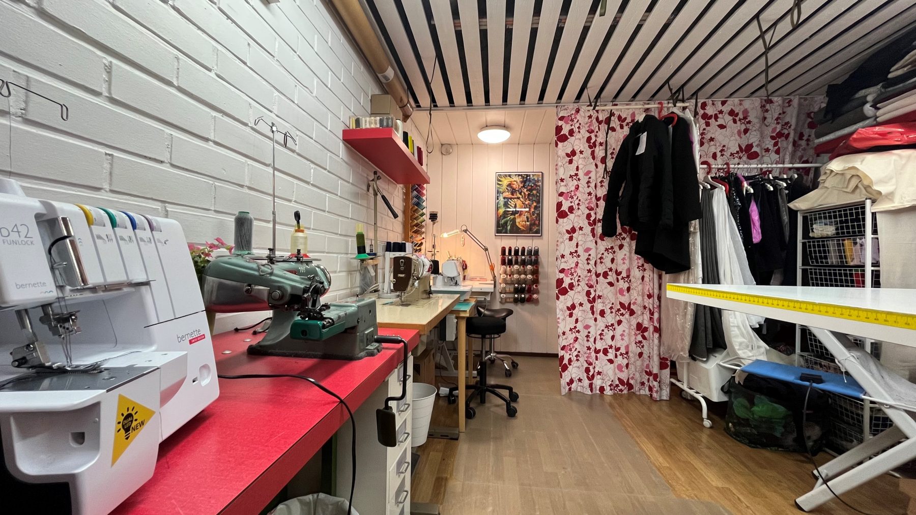 Kuva Sellistin sauman ompelimosta jossa näkyy ompelukoneita, tarvikkeita ja pukuhuone